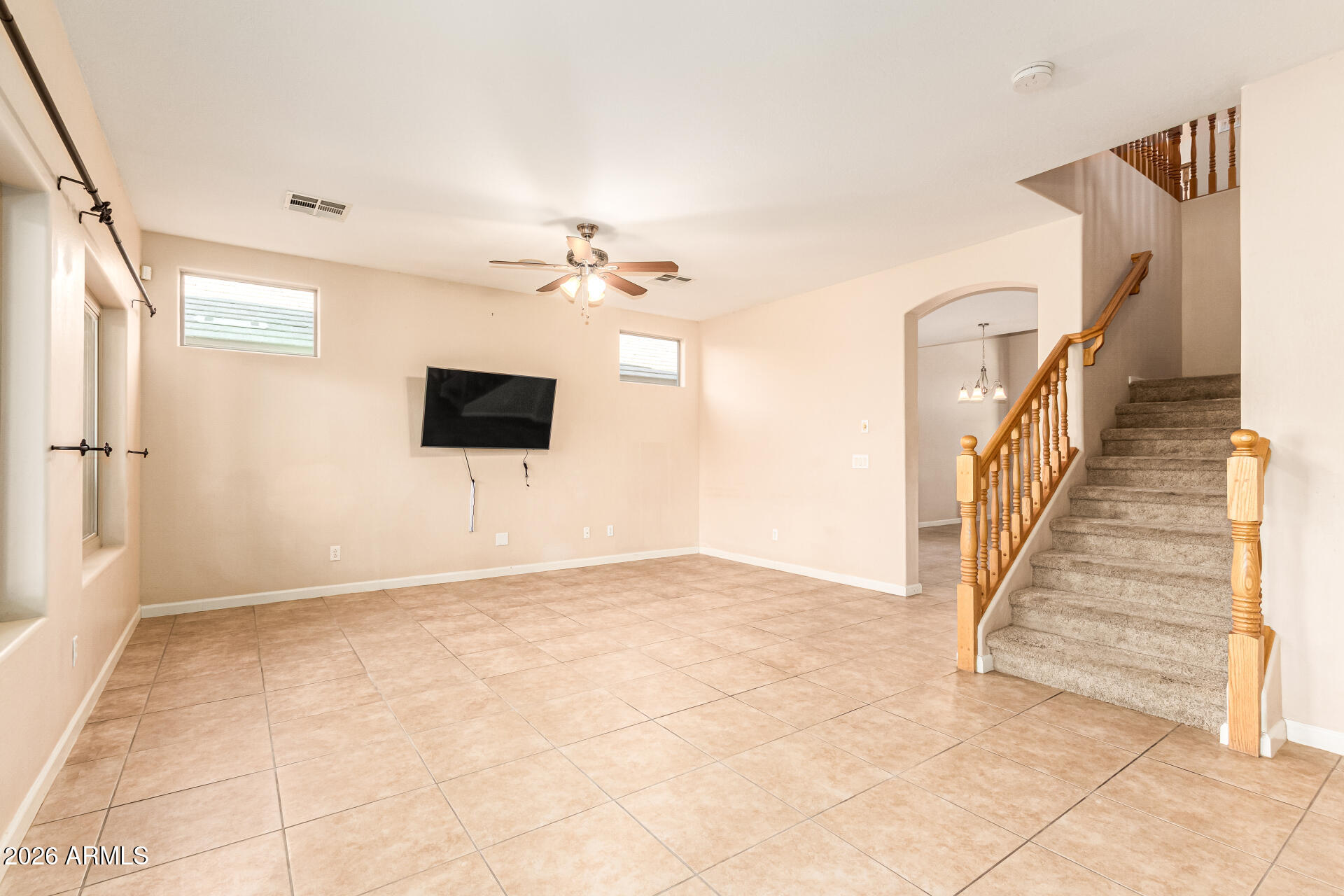 25660 West Dunlap Road Buckeye, AZ 85326 - Photo 8 of 40 a view of an empty room with stairs and a chandelier fan