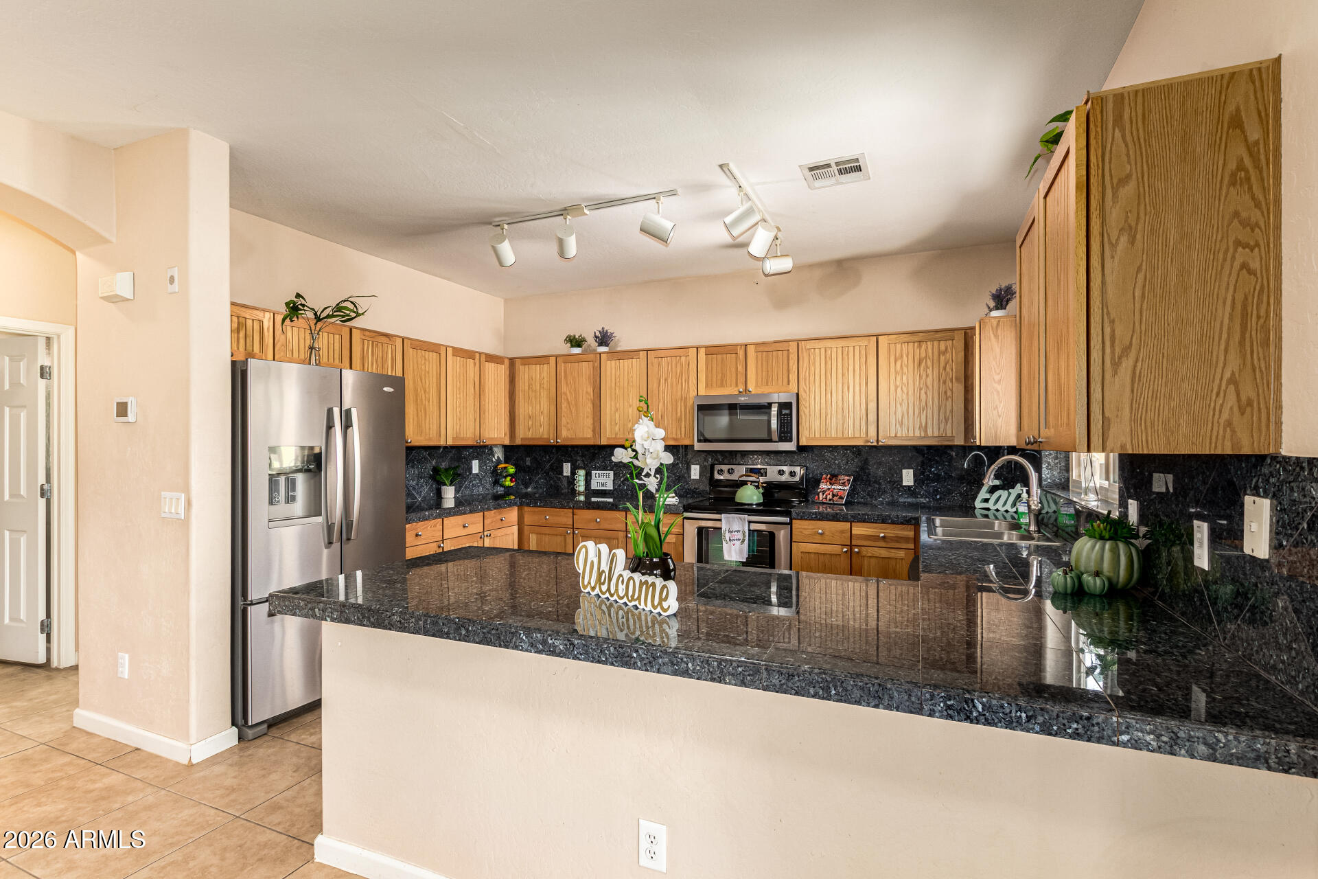 25660 West Dunlap Road Buckeye, AZ 85326 - Photo 10 of 40 a kitchen with stainless steel appliances granite countertop a refrigerator a sink and a stove