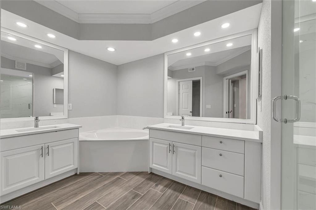 10771 Crooked River Road, Unit 103 Estero, FL 34135 - Photo 12 of 21 a bathroom with a tub a sink double vanity and a mirror