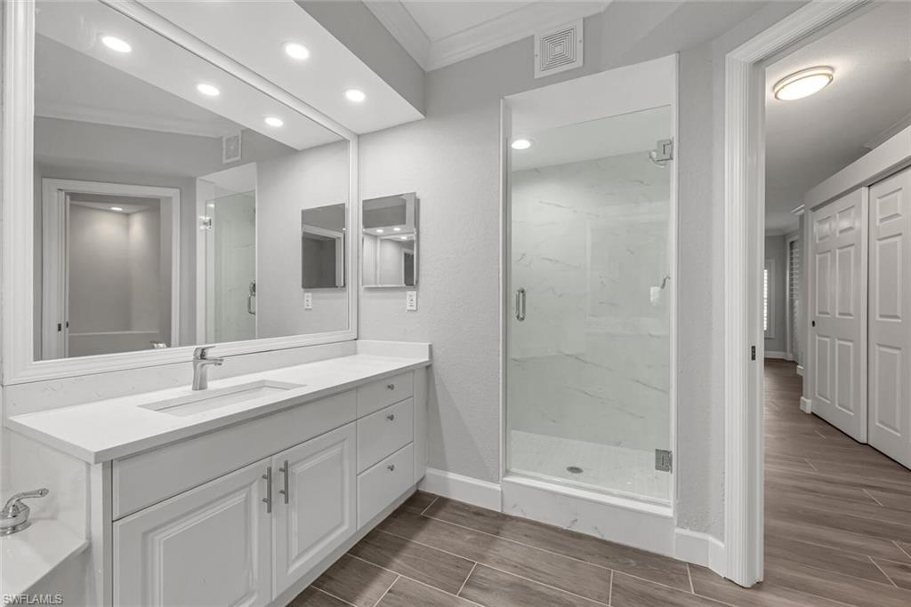 10771 Crooked River Road, Unit 103 Estero, FL 34135 - Photo 13 of 21 a bathroom with a shower sink double vanity and mirror
