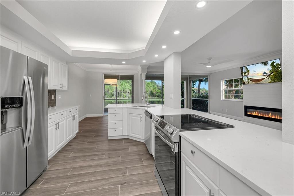 10771 Crooked River Road, Unit 103 Estero, FL 34135 - Photo 7 of 21 a kitchen with granite countertop a sink stove and refrigerator