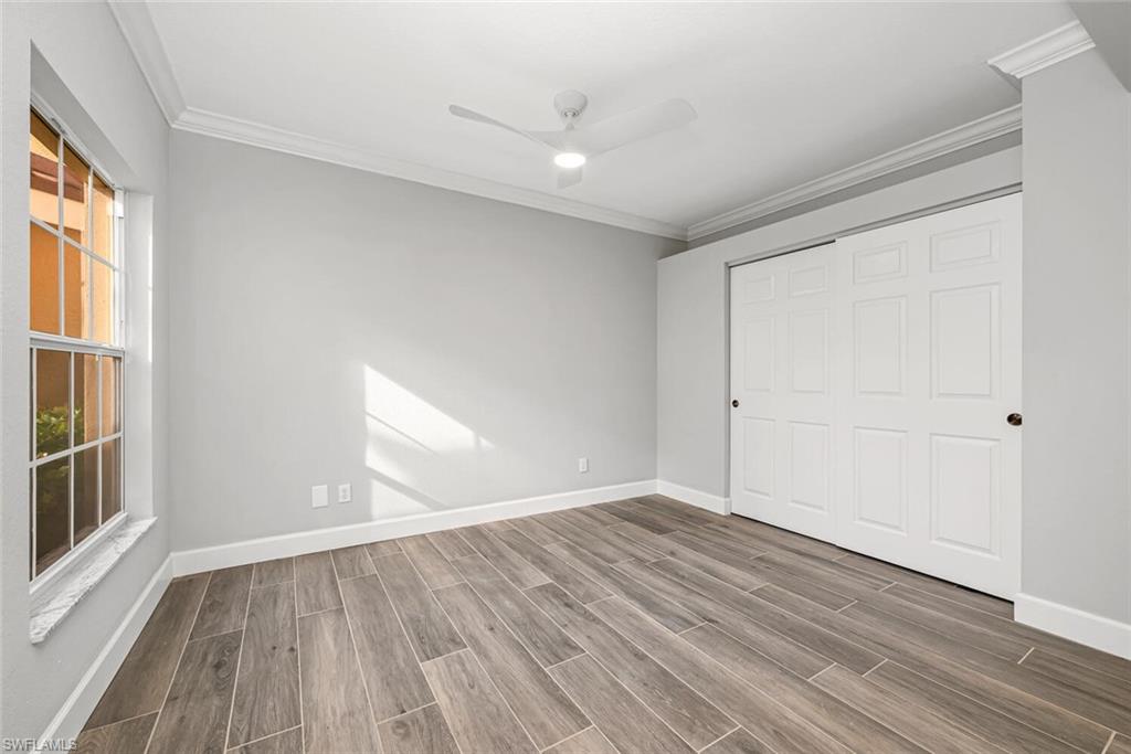 10771 Crooked River Road, Unit 103 Estero, FL 34135 - Photo 10 of 21 wooden floor in an empty room with a window