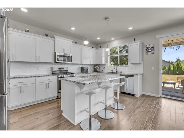 a kitchen with kitchen island granite countertop a sink cabinets and wooden floor