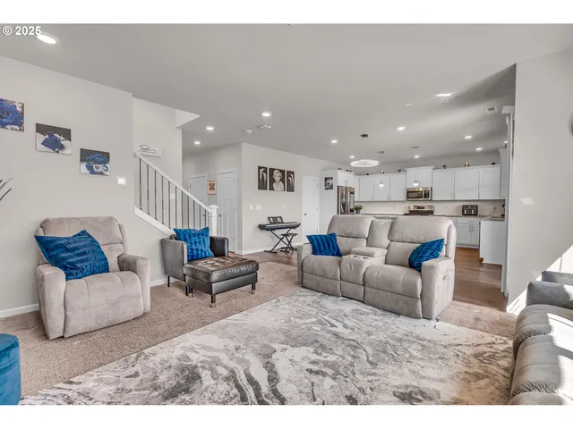 a living room with furniture and a view of kitchen