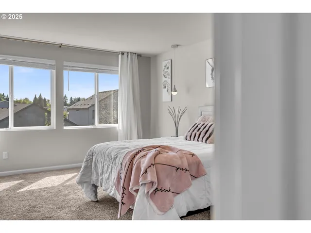 a bedroom with a bed and a large window