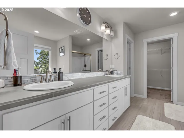a bathroom with double vanity sinks and a mirror