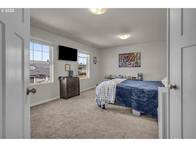 a spacious bedroom with a bed and a flat screen tv