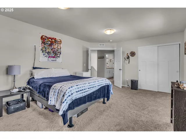 a spacious bedroom with a bed and a cabinets
