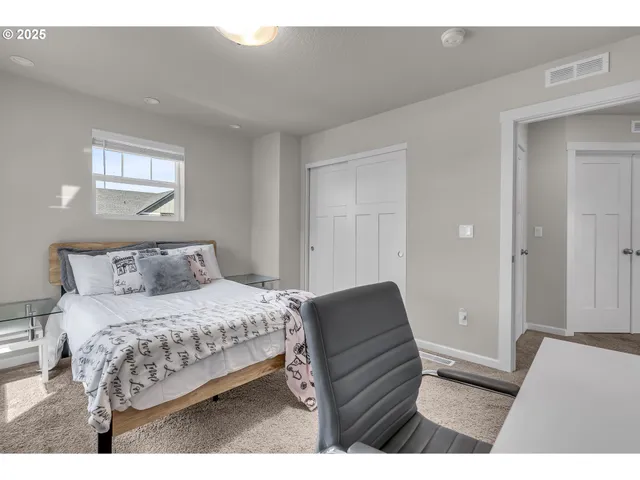 a bedroom with a bed window and a mirror