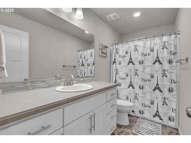 a bathroom with a granite countertop sink a toilet and a mirror