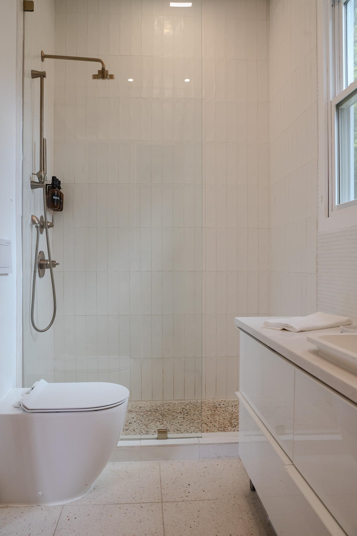 210 North Avalon Street Memphis, TN 38112 - Photo 16 of 30 Bathroom featuring vanity, toilet, tiled shower, and plenty of natural light