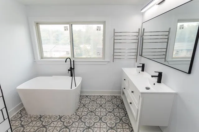 a white bath tub sitting in a bathroom next to a window