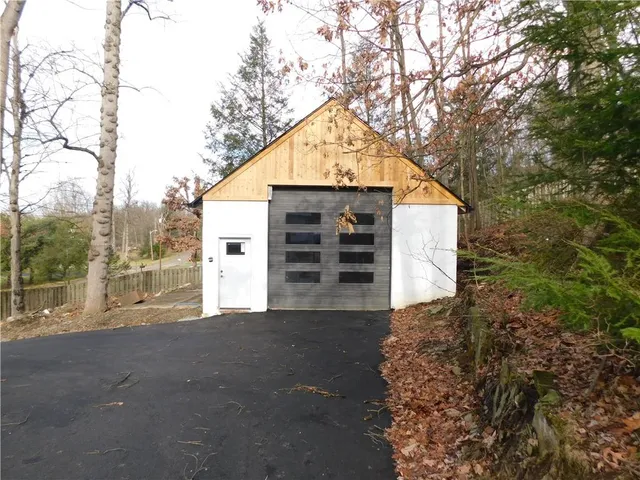 a view of a house with a large tree and wooden fence