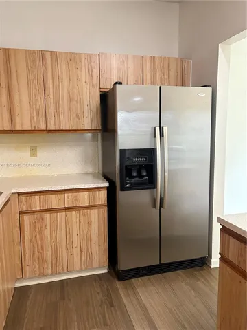 a kitchen with a refrigerator sink and cabinets