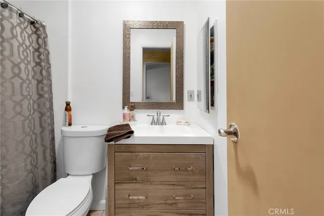 a bathroom with a sink a toilet and mirror