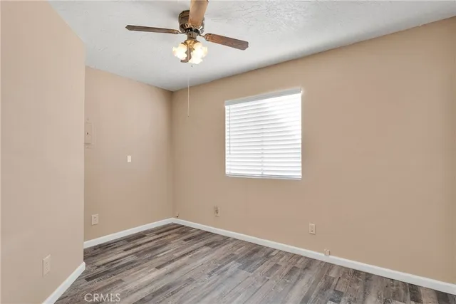an empty room with a window and a ceiling fan