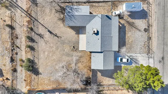 a aerial view of a house with a yard and large trees