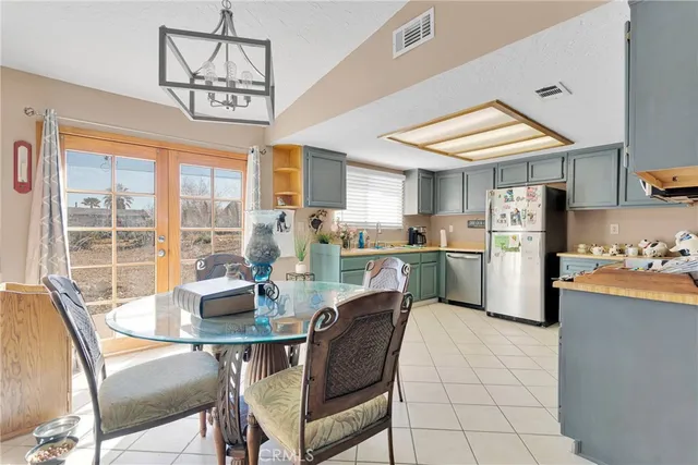 a dining room with stainless steel appliances granite countertop a dining table chairs and a microwave