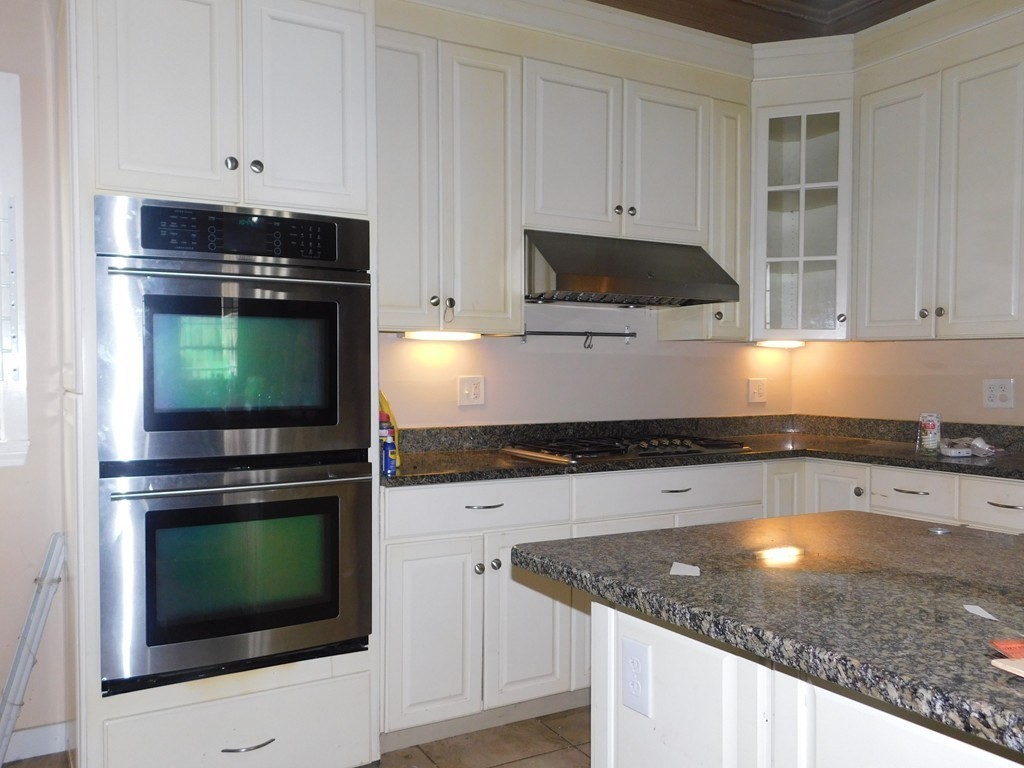 a kitchen with granite countertop a stove and a sink