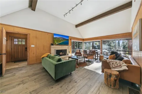 a living room with fireplace furniture and a large window