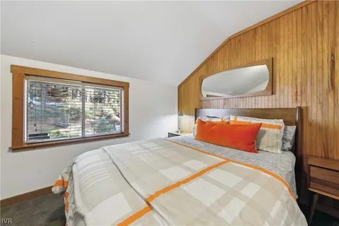 a bedroom with a large bed and a painting on the wall