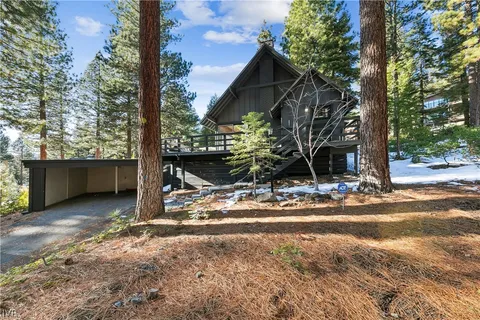 a view of a house with backyard and trees