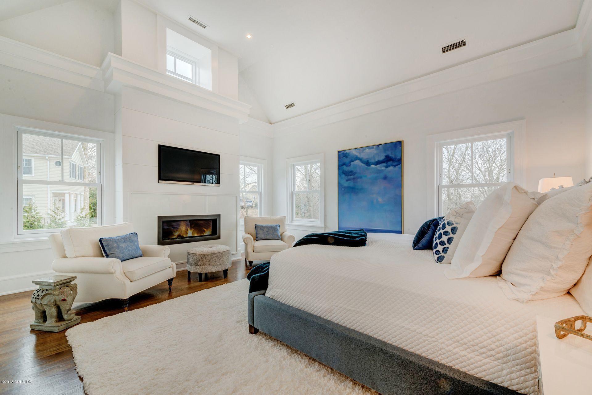 10 Lakeview Drive Riverside, CT 06878 - Photo 15 of 28 a bedroom with bed a flat tv screen and a fireplace