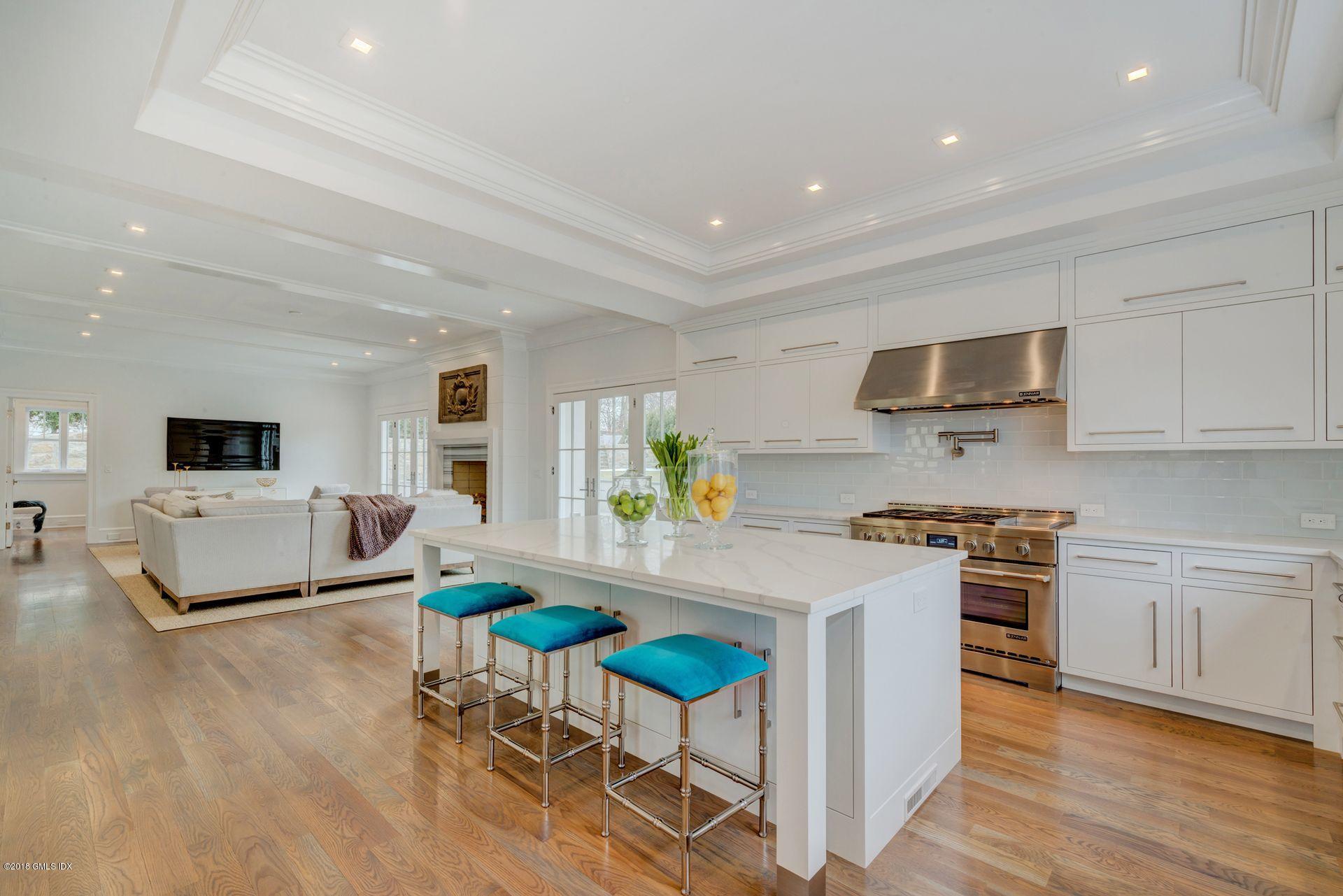 10 Lakeview Drive Riverside, CT 06878 - Photo 5 of 28 a kitchen with stainless steel appliances granite countertop a stove top oven a sink a dining table and chairs with wooden floor