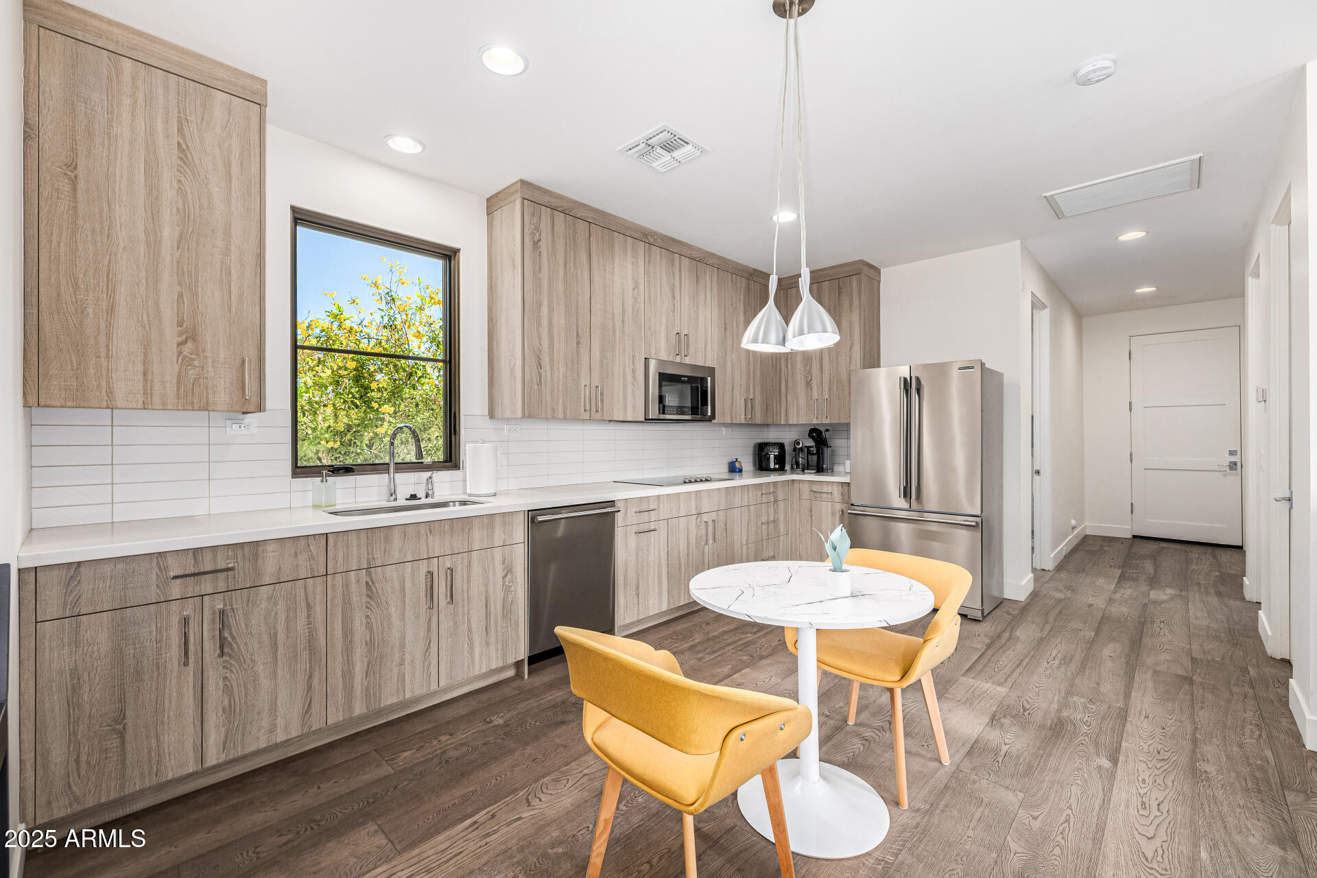 4535 North 49th Place Phoenix, AZ 85018 - Photo 55 of 75 a kitchen with stainless steel appliances kitchen island granite countertop a kitchen island a stove a table and chairs in it