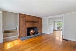 a view of empty room with fireplace and wooden floor
