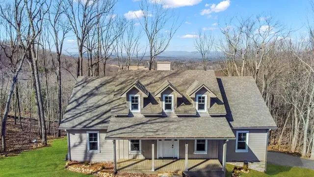 an empty room with wooden floor fireplace and windows