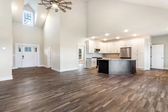 a view of a kitchen with kitchen island a sink stainless steel appliances and cabinets