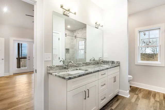 a bathroom with a granite countertop sink and a mirror