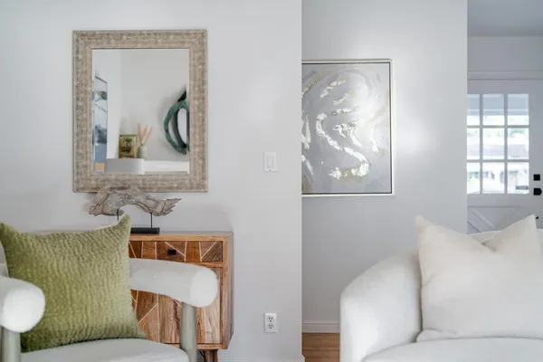 a living room with couches and painting on the wall next to a window