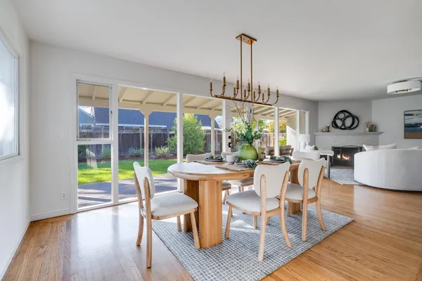 a view of a dining room with furniture a chandelier and wooden floor