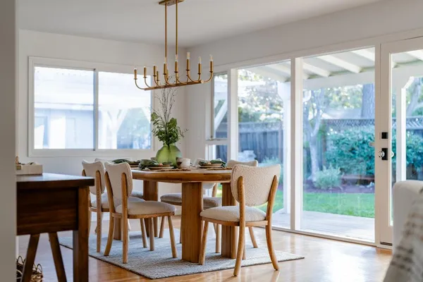 a dining room with furniture a chandelier and wooden floor