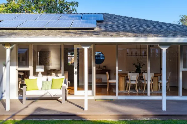 a view of a patio with table and chairs under an umbrella with a big yard
