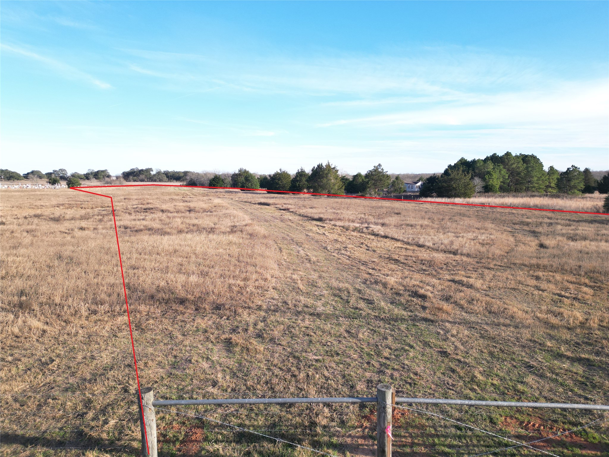 4 Trinity School Road La Grange, TX 78945 - Photo 8 of 11 Fenced pastures unfold under a vast open sky with mature trees bordering the property line.