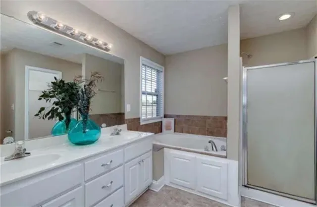 a bathroom with double vanity and a mirror