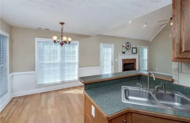 a kitchen with kitchen island granite countertop a sink stainless steel appliances and cabinets