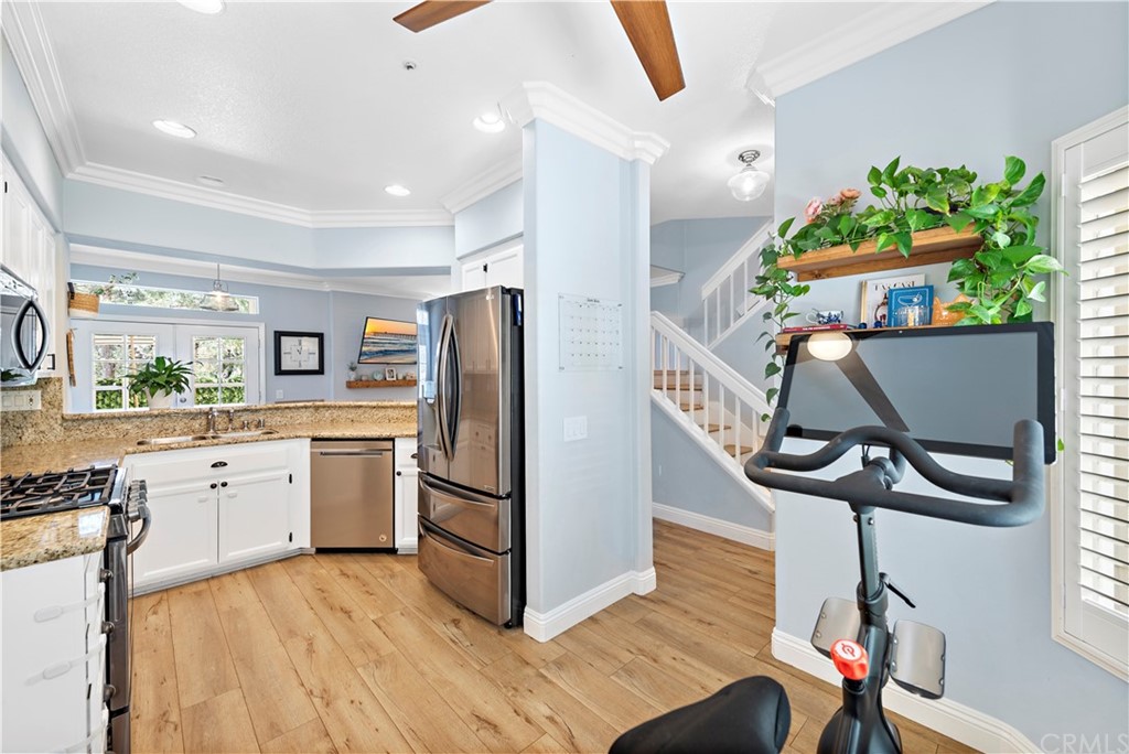 6 Via Madera Rancho Santa Margarita, CA 92688 - Photo 1 of 1 a kitchen with stainless steel appliances granite countertop a refrigerator a stove a sink dishwasher and a dining table with wooden floor