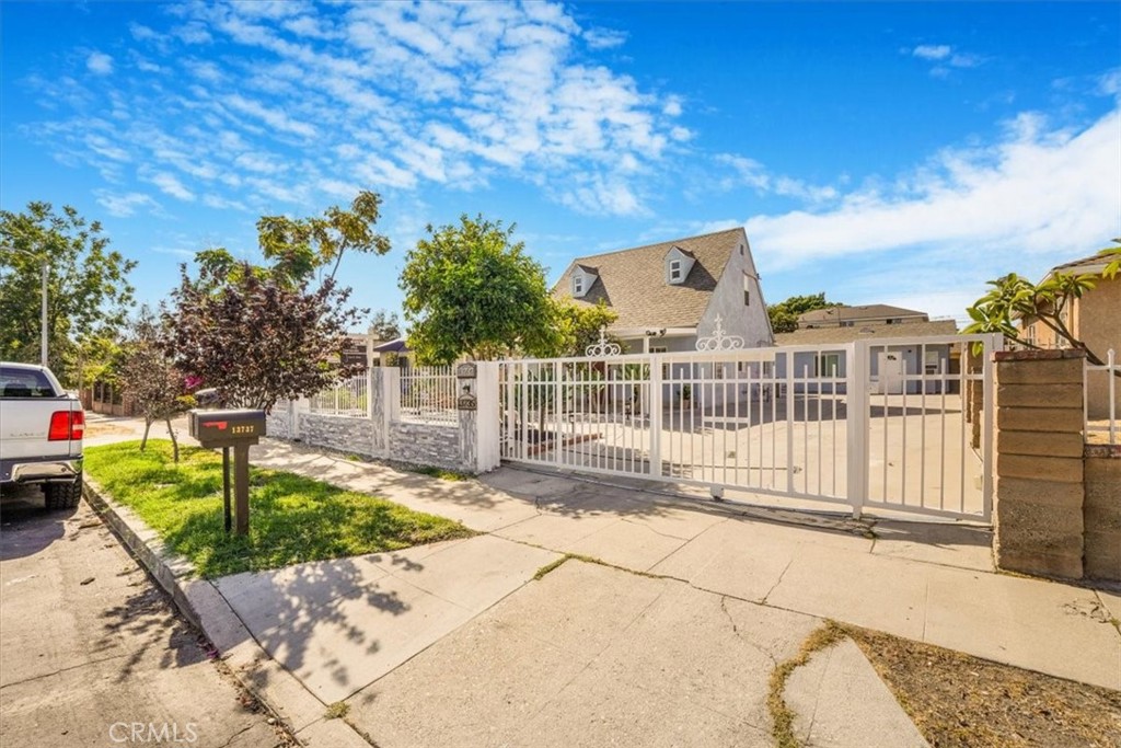 a view of a house with a small yard and wooden fence