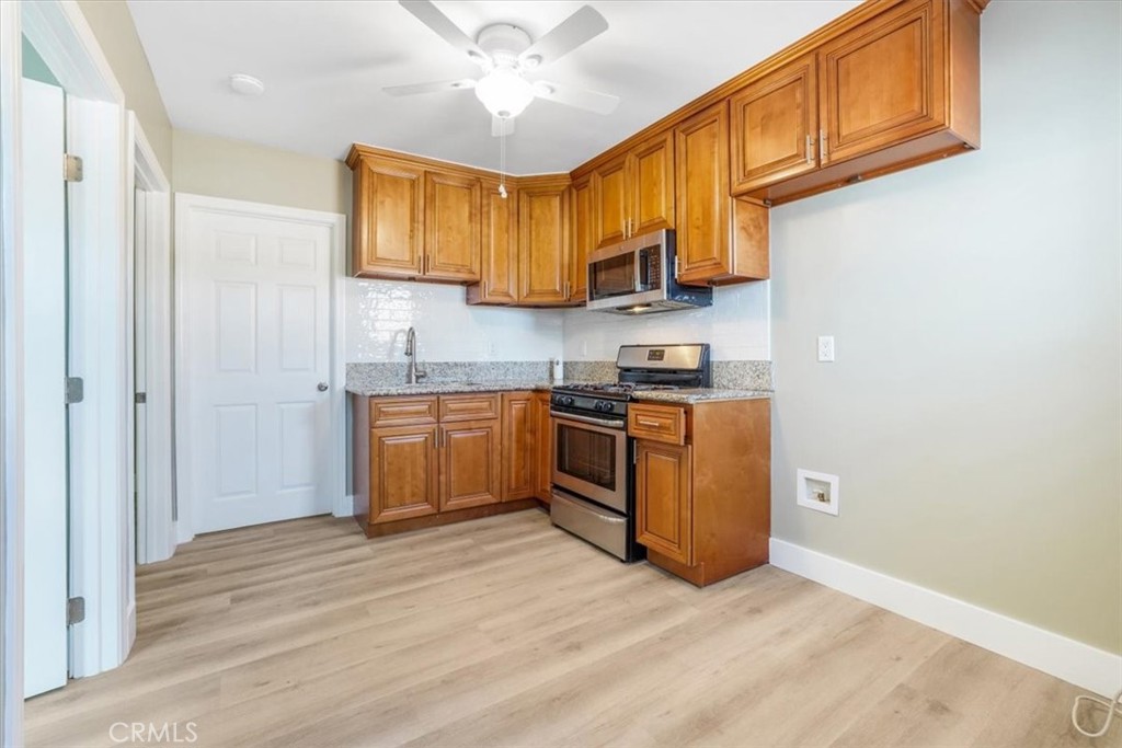 13737 Mercer Street Pacoima, CA 91331 - Photo 22 of 35 a kitchen with stainless steel appliances granite countertop a stove a sink and a refrigerator