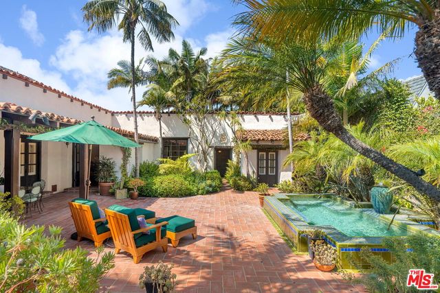 a view of a patio with a table and chairs under an umbrella