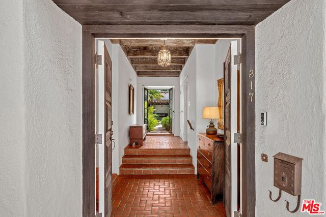 a view of a hallway with wooden floor and windows