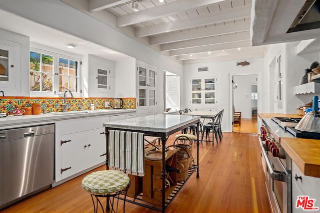 a open kitchen with stainless steel appliances granite countertop a stove a sink a dining table and chairs