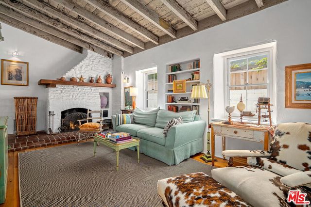 a living room with furniture fireplace and a window
