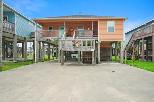 a view of a house with a yard and table and chairs under an umbrella