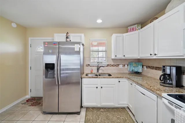 a large white kitchen with cabinets and appliances