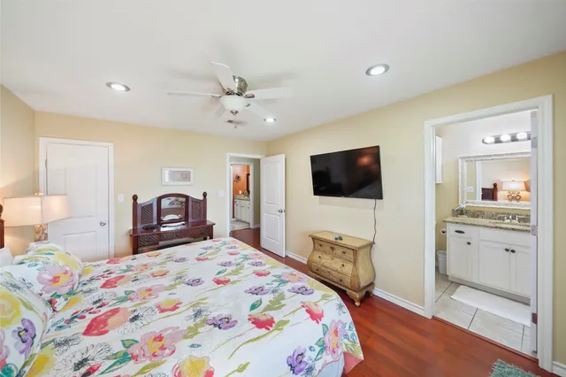 a bedroom with a bed a dresser and flat screen tv